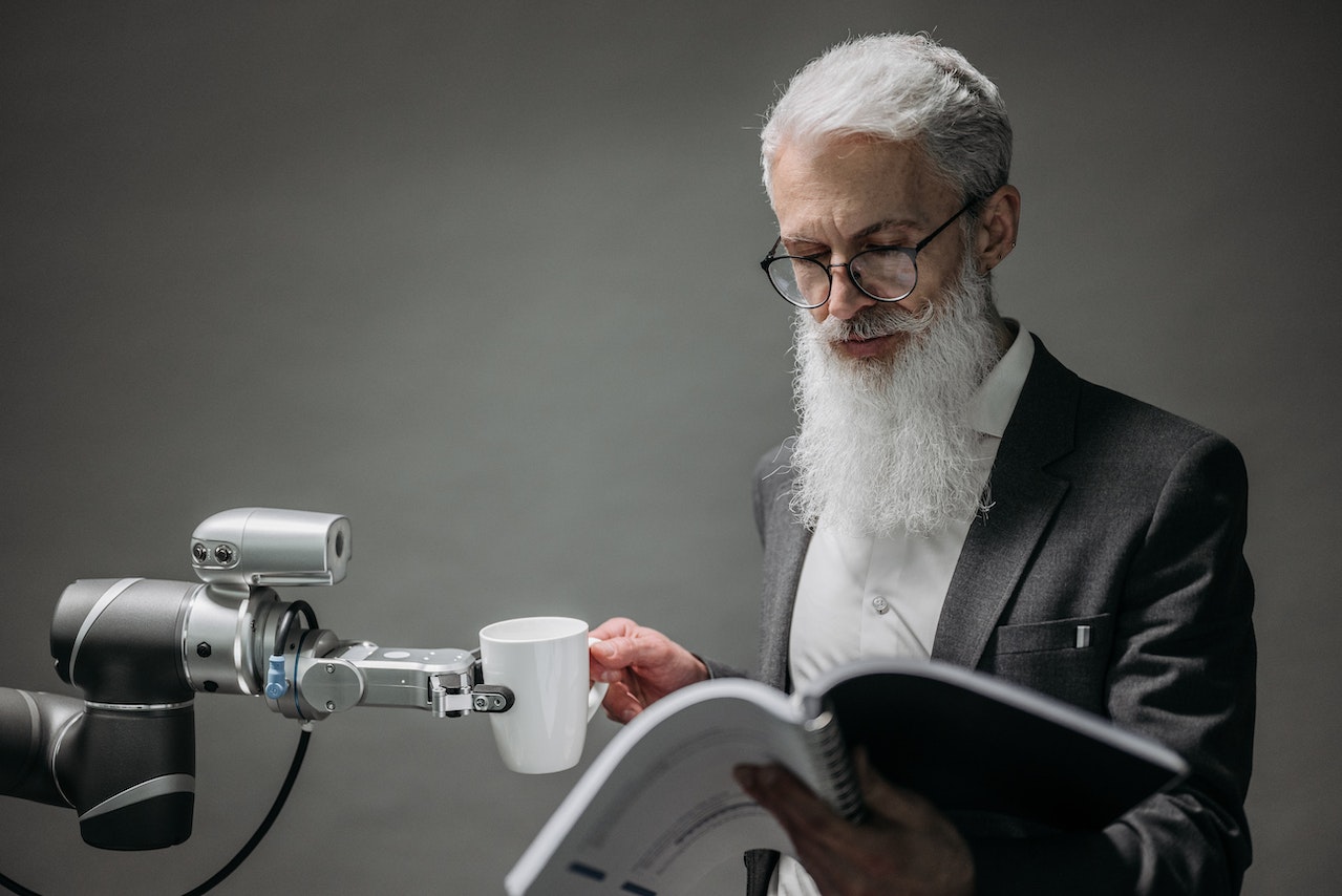 Man Reading A Book with A Robotic Arm