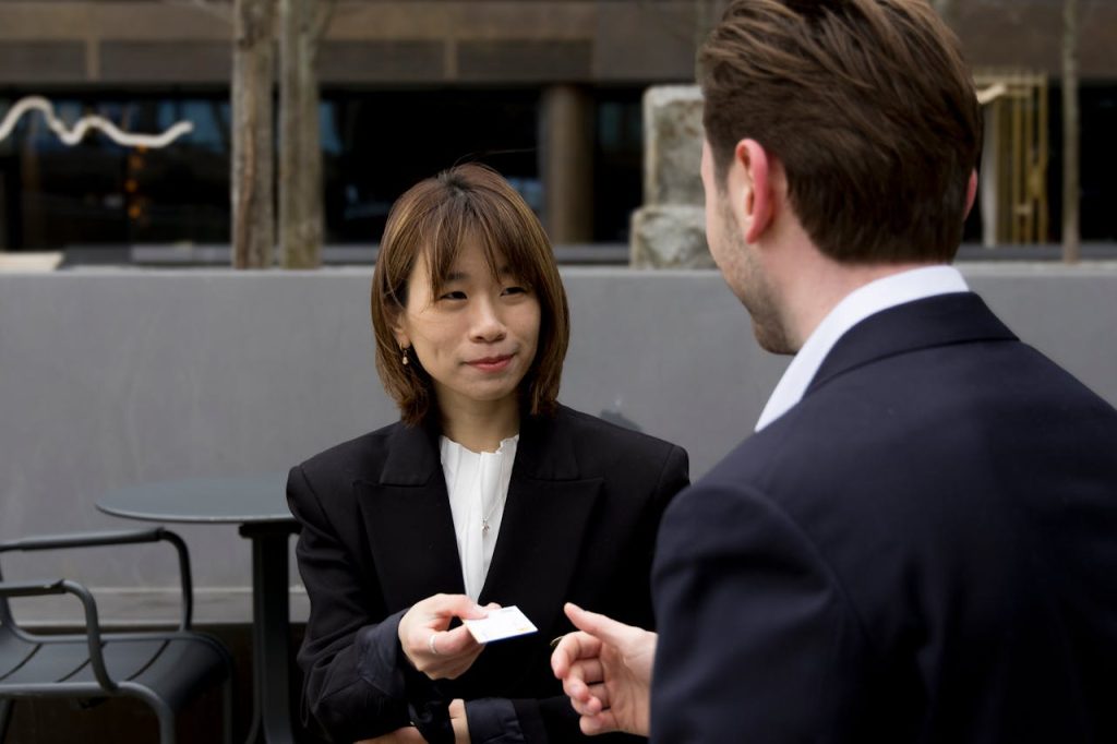 Smiling Businessman and Businesswoman Exchanging a Business Card